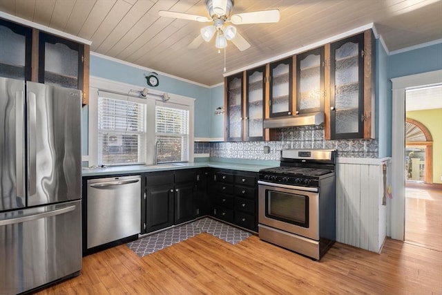 kitchen featuring crown molding, stainless steel appliances, light hardwood / wood-style flooring, and backsplash