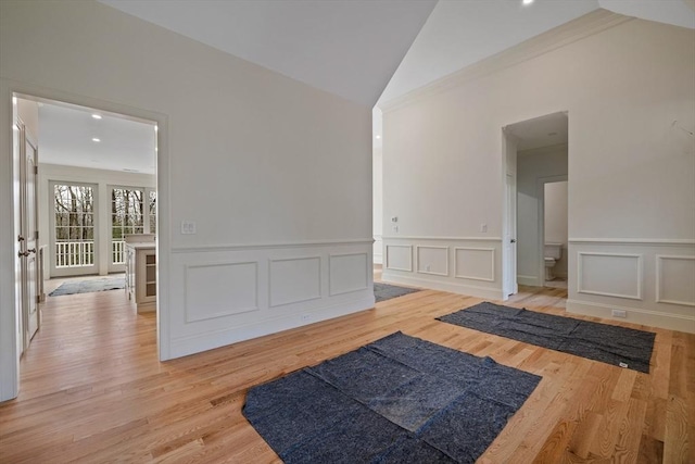 unfurnished room featuring light wood-type flooring, lofted ceiling, and crown molding