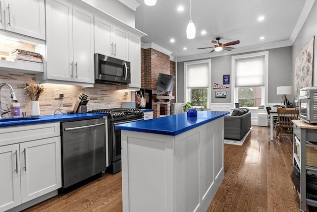1411 Washington St Unit 4, Boston, MA 02118 - kitchen featuring appliances with stainless steel finishes, ornamental molding, a ceiling fan, dark countertops, and wood finished floors