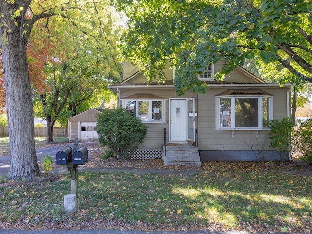 view of front of home with a front yard, an outbuilding, and a garage