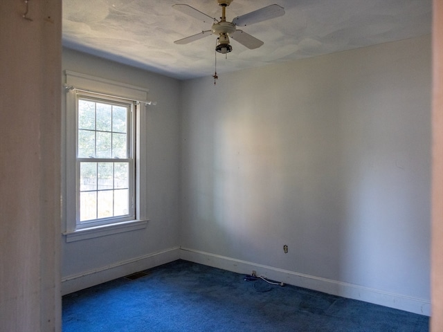 empty room featuring ceiling fan and carpet