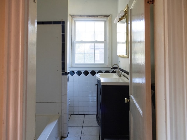 bathroom with vanity, tile walls, a bathtub, and tile patterned flooring