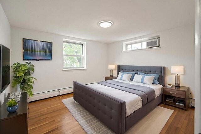 12 Commonwealth Ct Unit 12-16, Boston, MA 02135 - bedroom with a baseboard radiator, wood finished floors, and a wall mounted air conditioner