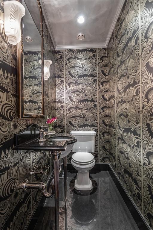 bathroom with crown molding and toilet