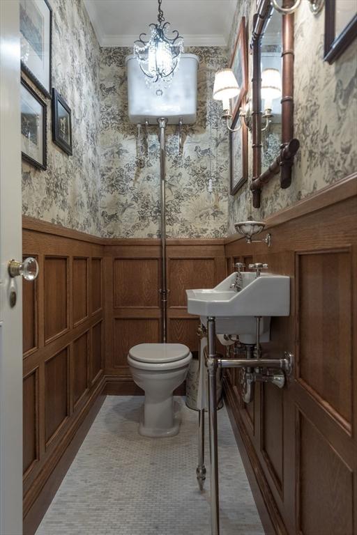 bathroom with sink, ornamental molding, a chandelier, and toilet