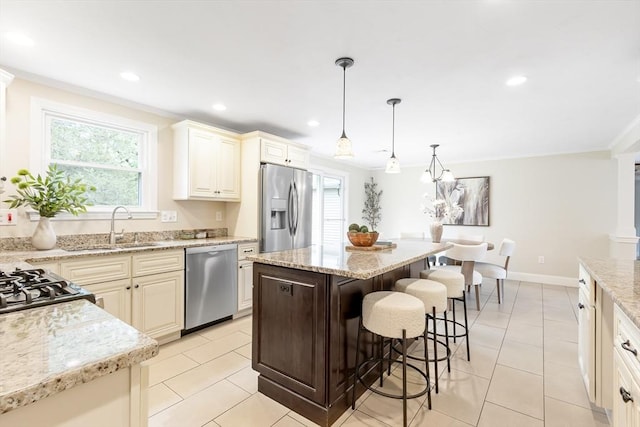 7 Langdon Rd, Natick, MA 01760 - kitchen featuring appliances with stainless steel finishes, a sink, a kitchen breakfast bar, light stone countertops, and light tile patterned flooring