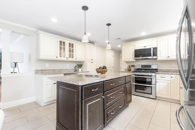 7 Langdon Rd, Natick, MA 01760 - kitchen with stainless steel appliances, light tile patterned floors, crown molding, dark brown cabinets, and a center island