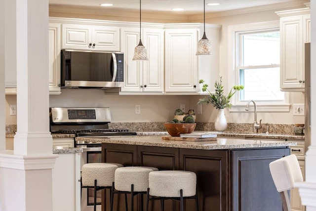 7 Langdon Rd, Natick, MA 01760 - kitchen featuring appliances with stainless steel finishes, a kitchen breakfast bar, white cabinets, and ornamental molding