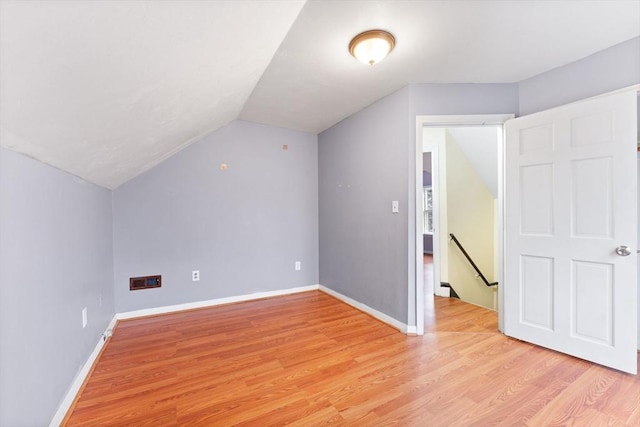 additional living space featuring lofted ceiling and light wood-type flooring