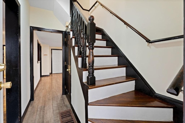 stairs featuring hardwood / wood-style flooring