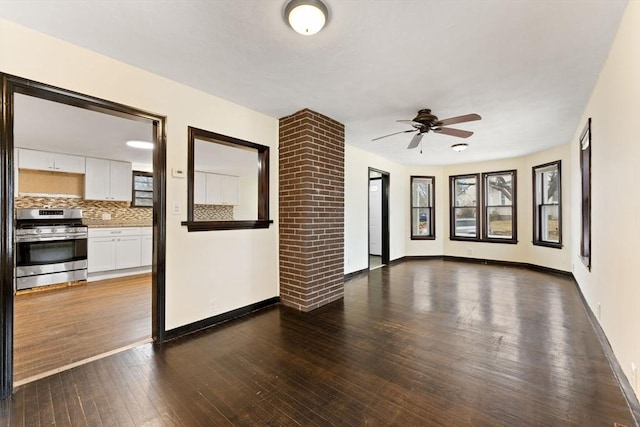 unfurnished living room featuring ceiling fan and dark hardwood / wood-style flooring