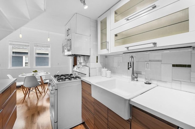 23 Turner St Unit 4, Salem, MA 01970 - kitchen featuring white appliances, glass insert cabinets, white cabinets, light wood finished floors, and light countertops