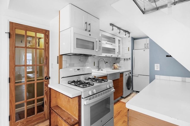 23 Turner St Unit 4, Salem, MA 01970 - kitchen with white appliances, washer / dryer, tasteful backsplash, white cabinets, and light countertops