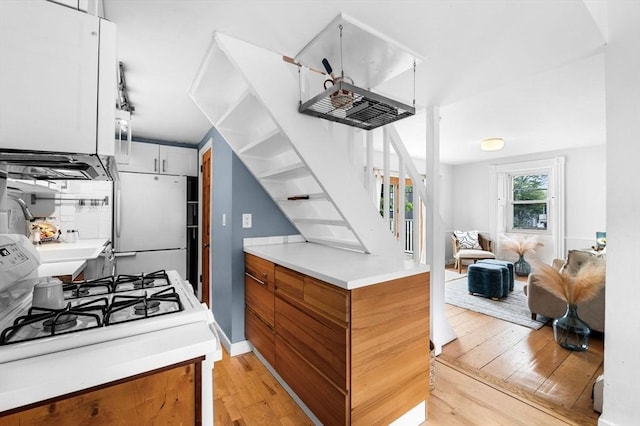 23 Turner St Unit 4, Salem, MA 01970 - kitchen with light wood-style flooring, white appliances, light countertops, and brown cabinets