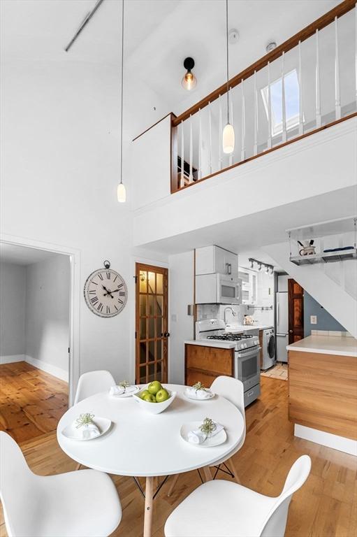 23 Turner St Unit 4, Salem, MA 01970 - dining space featuring light wood-style floors, a high ceiling, and estacked washer and dryer