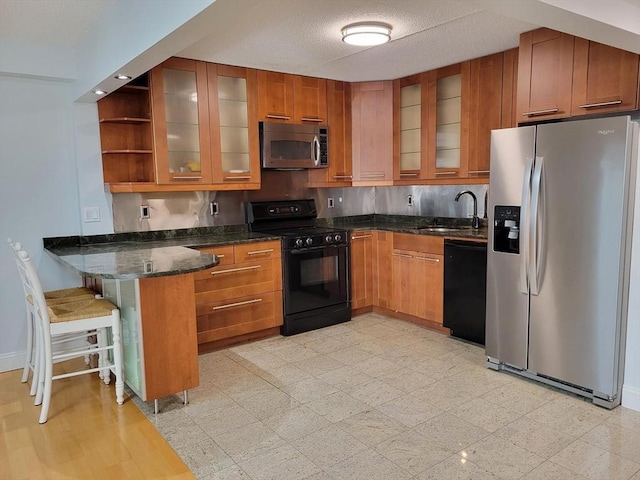200 Cove Way Unit 607, Quincy, MA 02169 - kitchen with black appliances, a peninsula, brown cabinets, and dark stone countertops