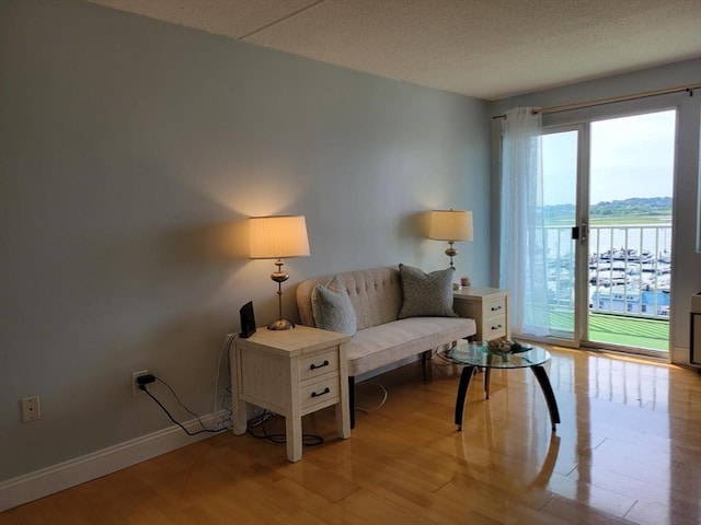 200 Cove Way Unit 607, Quincy, MA 02169 - living room featuring a water view, light wood-style flooring, and a textured ceiling
