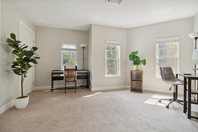 home office featuring carpet flooring, baseboards, and a wealth of natural light