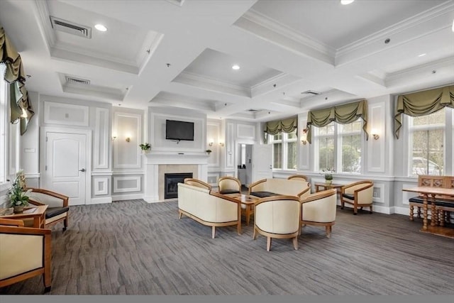 living room with visible vents, a glass covered fireplace, ornamental molding, and a decorative wall