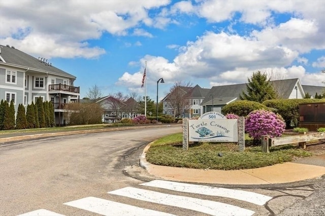 view of street with curbs, a residential view, street lighting, and sidewalks