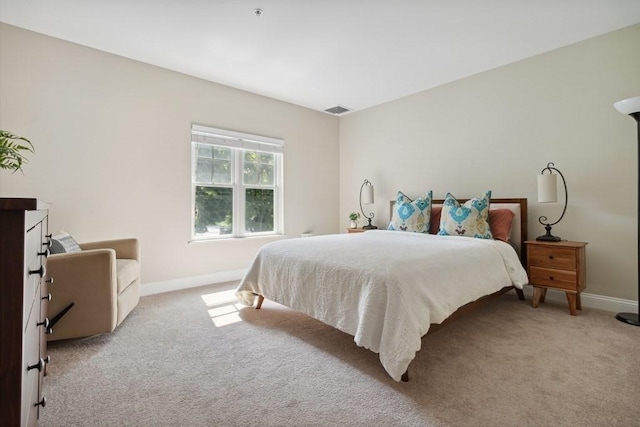 bedroom featuring visible vents, light colored carpet, and baseboards