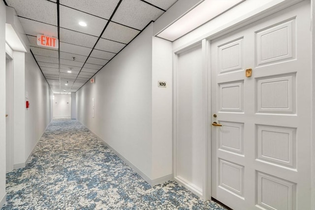 corridor with carpet floors and a drop ceiling