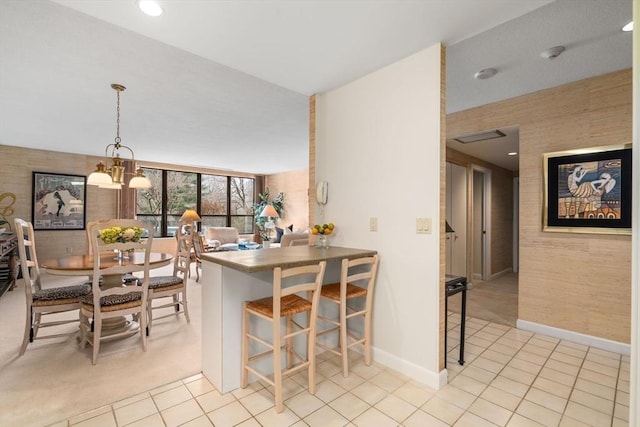 kitchen featuring a breakfast bar, pendant lighting, light tile patterned floors, and kitchen peninsula