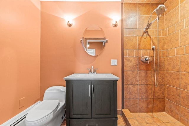 bathroom with vanity, a tile shower, and toilet