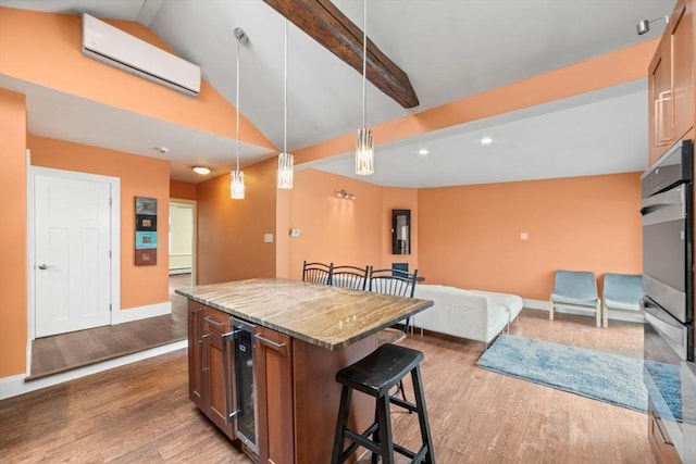 kitchen featuring a breakfast bar area, wood finished floors, baseboards, wine cooler, and vaulted ceiling with beams