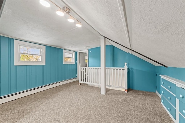 bonus room featuring a baseboard heating unit, carpet flooring, a textured ceiling, and lofted ceiling