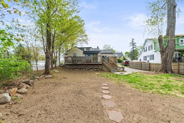 back of property with fence and a wooden deck