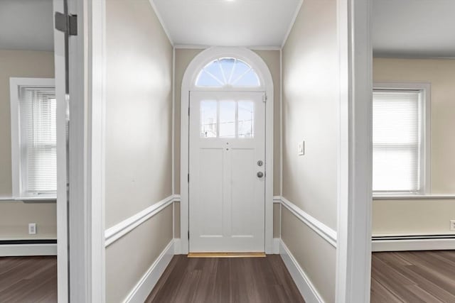 entryway featuring baseboards, ornamental molding, a baseboard heating unit, and dark wood finished floors