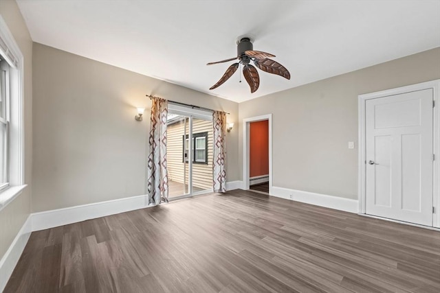 spare room with baseboards, a ceiling fan, a baseboard heating unit, and wood finished floors
