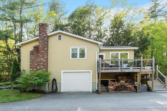 14 Mossman Rd, Westminster, MA 01473 - view of front of home with a chimney, an attached garage, a wooden deck, stairs, and driveway