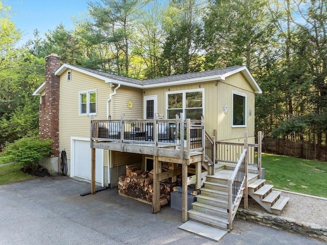 14 Mossman Rd, Westminster, MA 01473 - view of front of property with a chimney, a garage, a deck, asphalt driveway, and a front yard