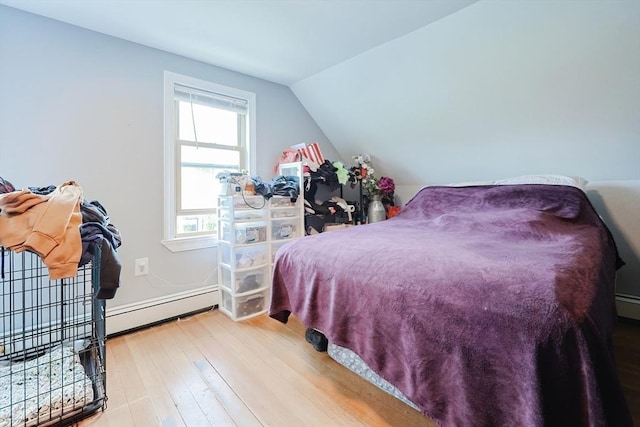 bedroom featuring a baseboard radiator, wood finished floors, and lofted ceiling
