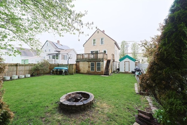 back of house featuring a shed, a fire pit, stairway, an outdoor structure, and a deck