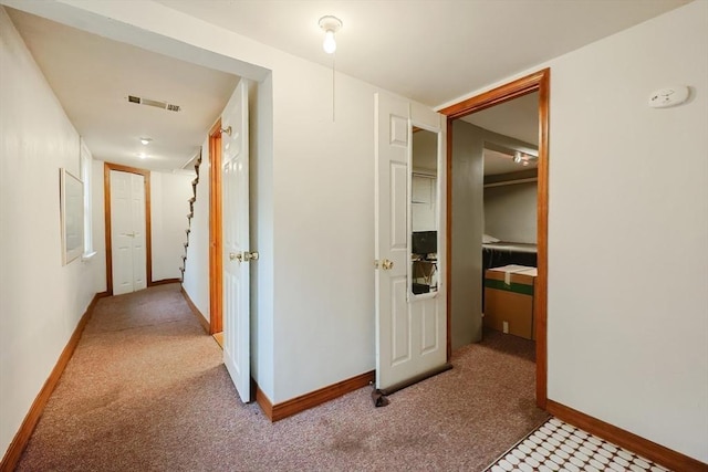 hallway featuring carpet floors and baseboards