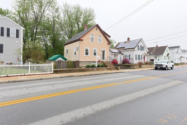 view of asphalt road with sidewalks, curbs, and a residential view