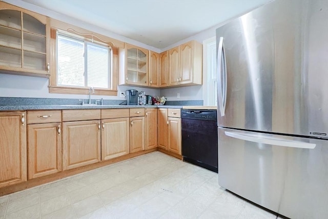 kitchen with freestanding refrigerator, black dishwasher, a sink, light brown cabinets, and glass insert cabinets