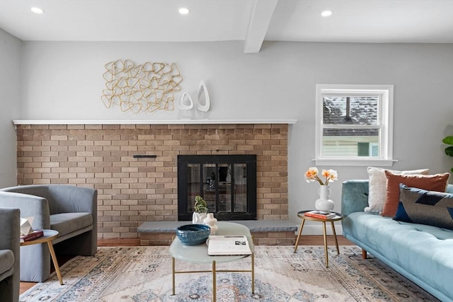 sitting room with hardwood / wood-style floors, beam ceiling, and a fireplace