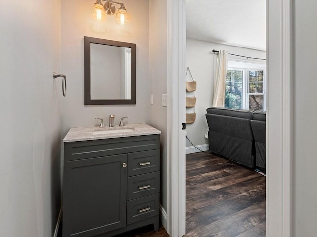 bathroom featuring baseboards, wood finished floors, and vanity