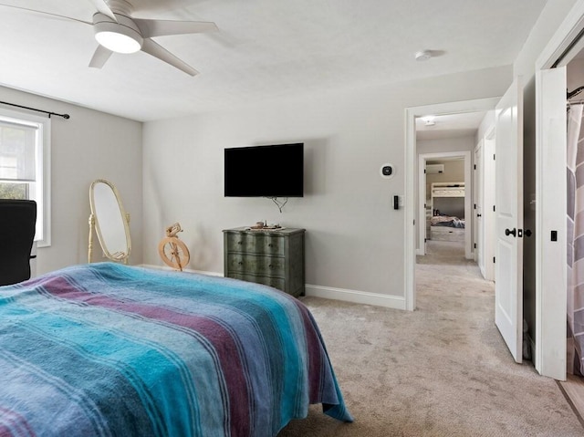 bedroom with light colored carpet, baseboards, and ceiling fan