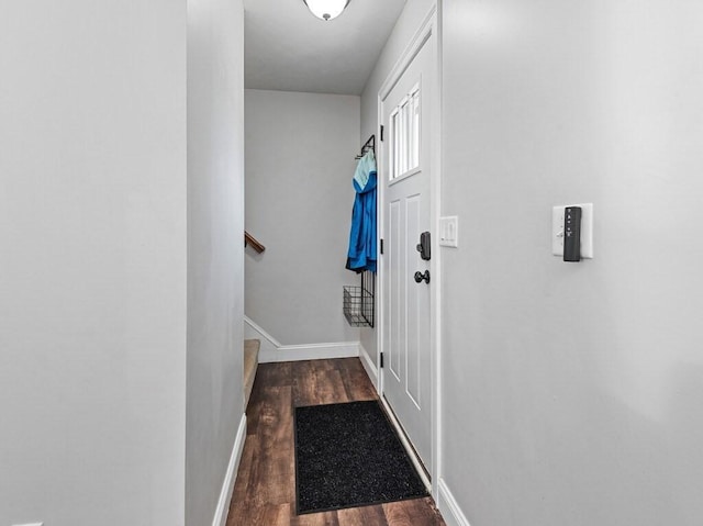 entryway with baseboards, wood finished floors, and stairway