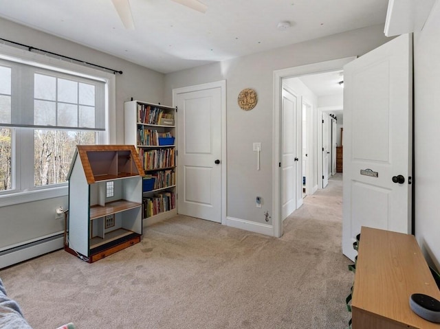 sitting room featuring a ceiling fan, baseboards, baseboard heating, and carpet