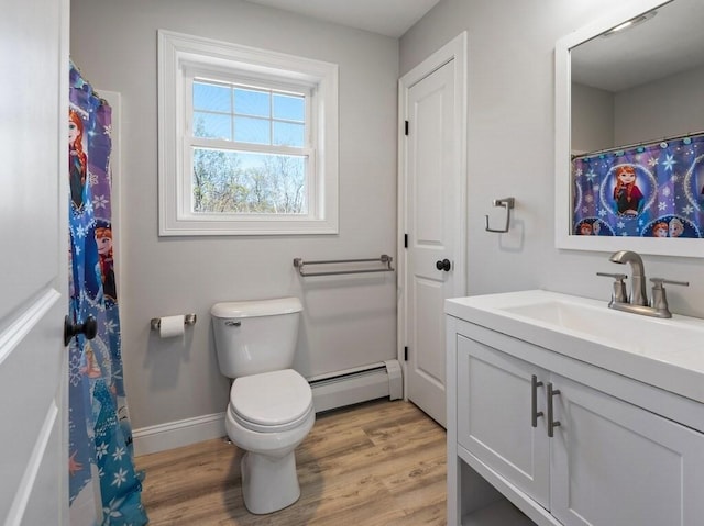 bathroom featuring baseboard heating, wood finished floors, vanity, baseboards, and toilet