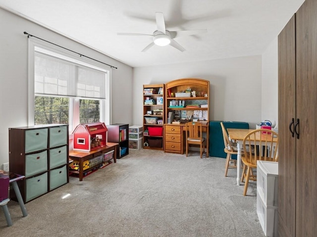 playroom with a ceiling fan and carpet