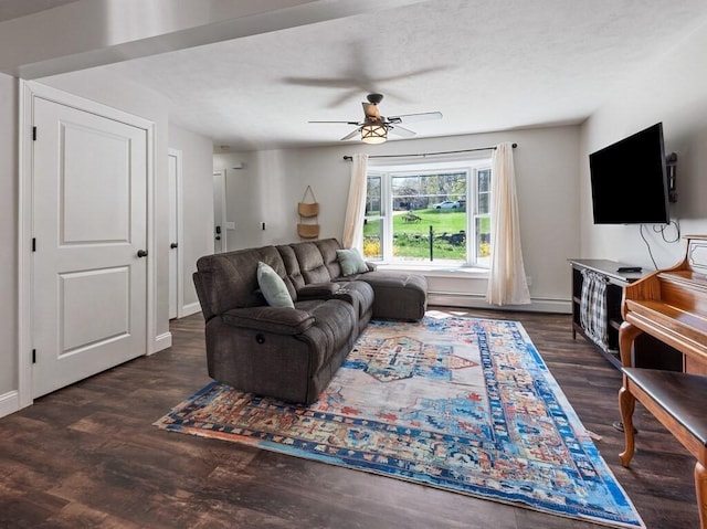 living area featuring baseboards, a ceiling fan, a baseboard heating unit, and wood finished floors