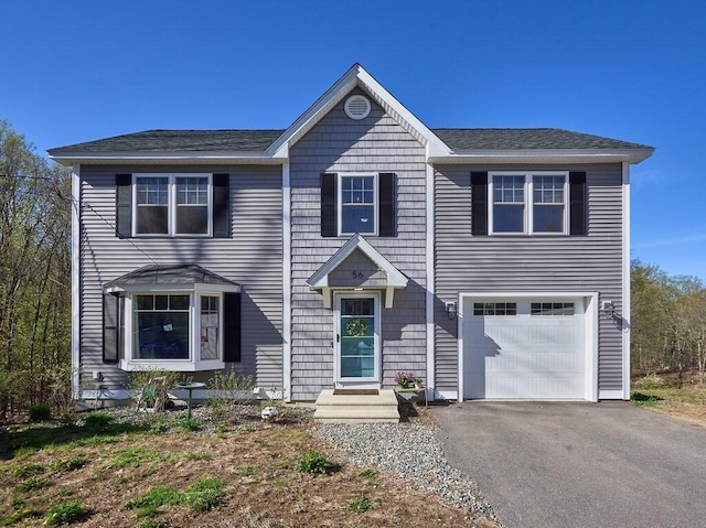 view of front facade with a garage, aphalt driveway, and roof with shingles