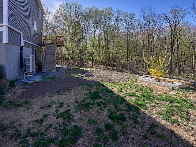 view of yard with stairway, central AC, and a deck